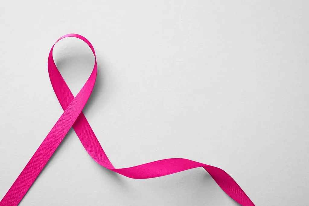 Pink Ribbon on White Background, Top View. Breast Cancer Awarene